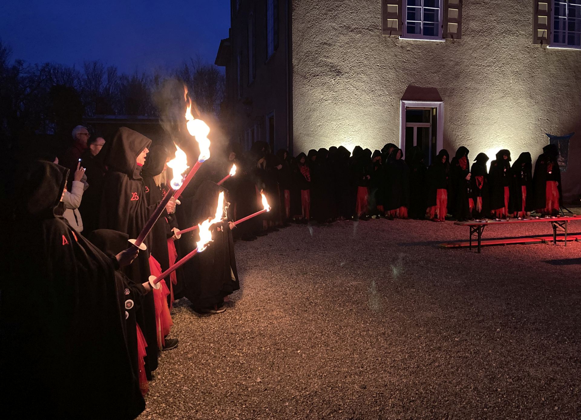 Hexen stehen beim Maskenabstauben in einer Reihe