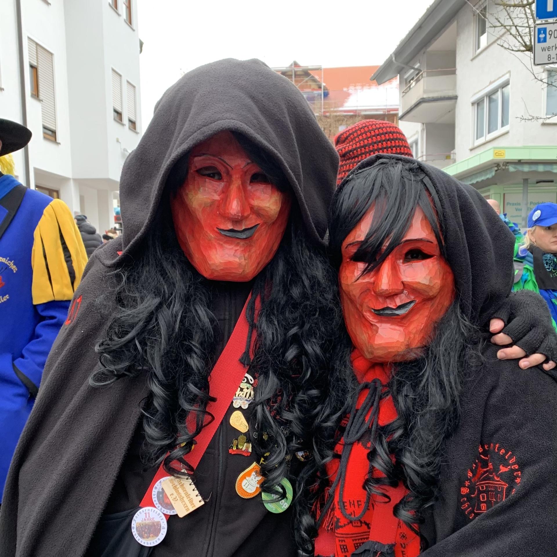 Vergrößern Zwei Maskenträger liegen sich im Arm